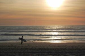 Silhouette de surfeur au coucher de soleil sur la plage de Lacanau